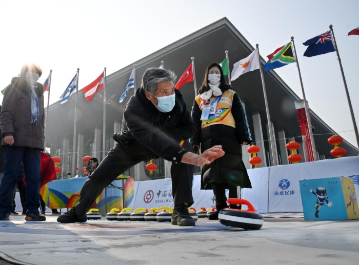 1月8日，一位市民在中国冰雪大篷车百场巡回青岛站活动中体验旱地冰壶。新华社记者李紫恒摄